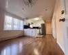 Kitchen featuring baseboard heating, stainless steel fridge, white cabinets, and light wood-type flooring