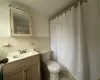 Bathroom with backsplash, vanity, toilet, and tile walls