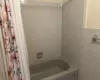 Bathroom with shower / bath combo and tile walls