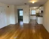 Kitchen featuring white cabinets, white appliances, sink, and hardwood / wood-style flooring