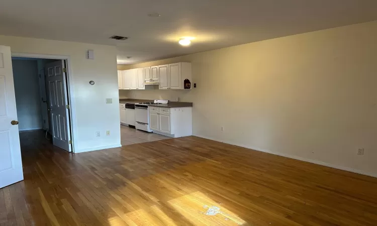 Kitchen featuring white cabinetry, white gas stove, and light wood-type flooring