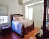 Bedroom featuring wood-type flooring, radiator heating unit, and an inviting chandelier