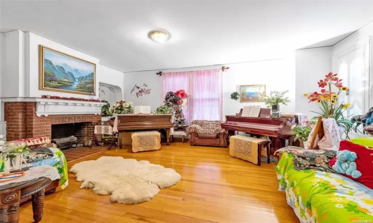 Living area with light wood-type flooring and a brick fireplace