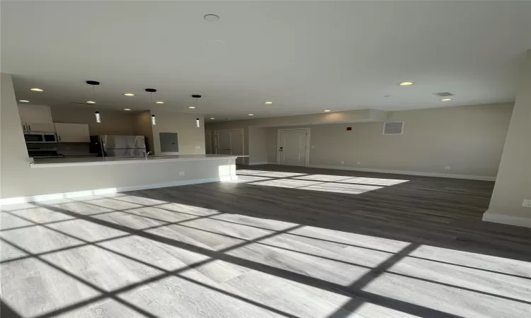 Unfurnished living room with light hardwood / wood-style flooring and sink