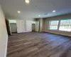 Unfurnished bedroom featuring dark hardwood / wood-style floors and multiple closets