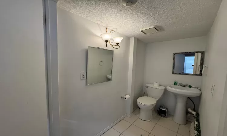 Bathroom featuring tile patterned flooring, toilet, and sink