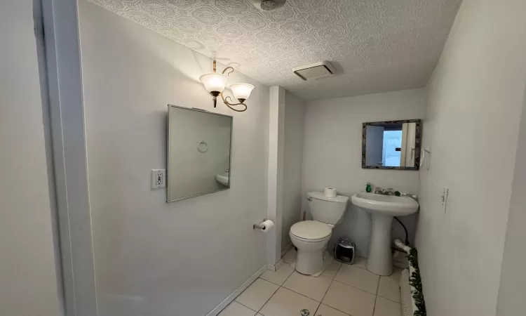 Bathroom with tile patterned floors, sink, and toilet