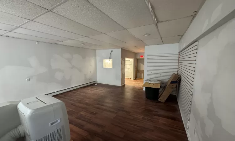 Basement featuring dark hardwood / wood-style flooring and a drop ceiling