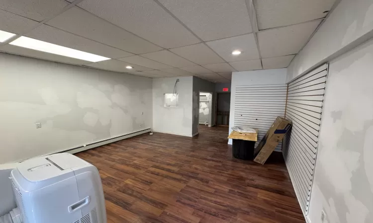 Basement with a paneled ceiling and dark wood-type flooring