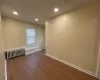 Empty room featuring radiator and hardwood / wood-style floors