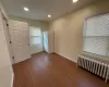 Spare room with radiator heating unit and hardwood / wood-style flooring