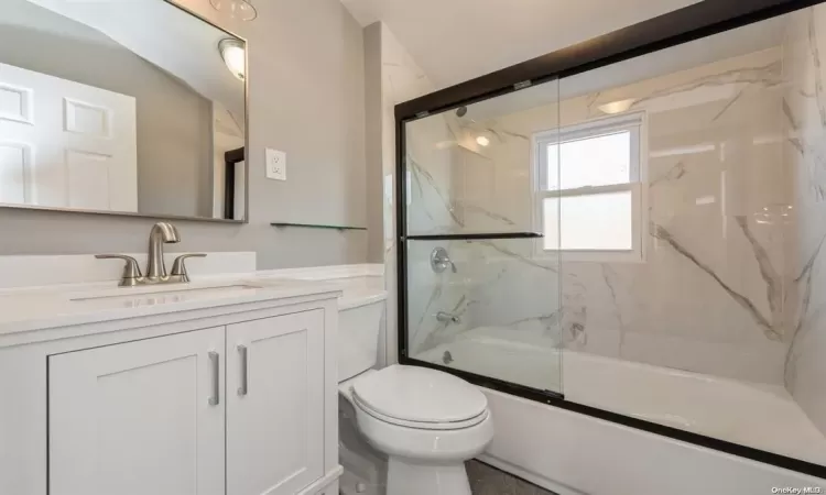 Full bathroom featuring vanity, toilet, and combined bath / shower with glass door