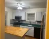 Kitchen featuring ceiling fan, sink, wood counters, backsplash, and appliances with stainless steel finishes