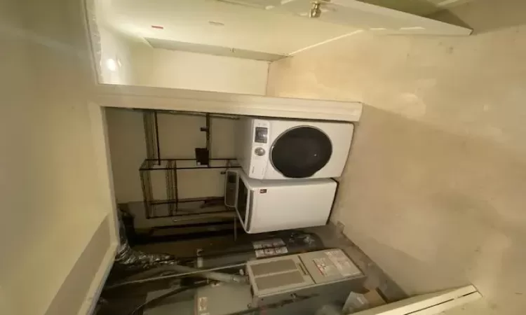 Clothes washing area featuring water heater and washer and dryer