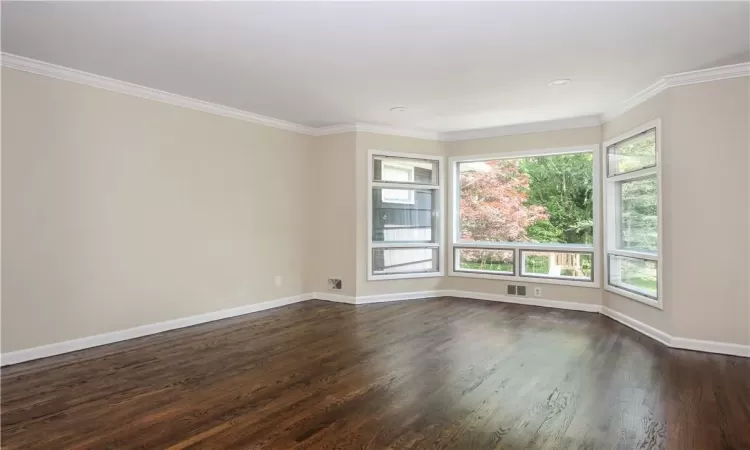 Formal living room with hardwood floors, recessed lighting, faces back yard