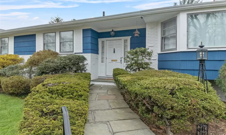 View of walkway and front door to property