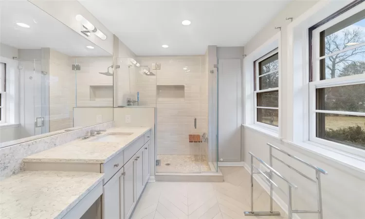 Bathroom featuring plenty of natural light, vanity, and an enclosed shower