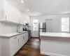 Kitchen featuring white cabinetry, sink, a wealth of natural light, dark wood-type flooring, and stainless steel appliances