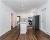 Kitchen with a center island, dark wood-type flooring, sink, white cabinetry, and stainless steel appliances