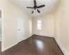 Unfurnished room featuring dark hardwood / wood-style floors, ceiling fan, and a baseboard heating unit