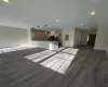 Unfurnished living room featuring electric panel, sink, and dark wood-type flooring