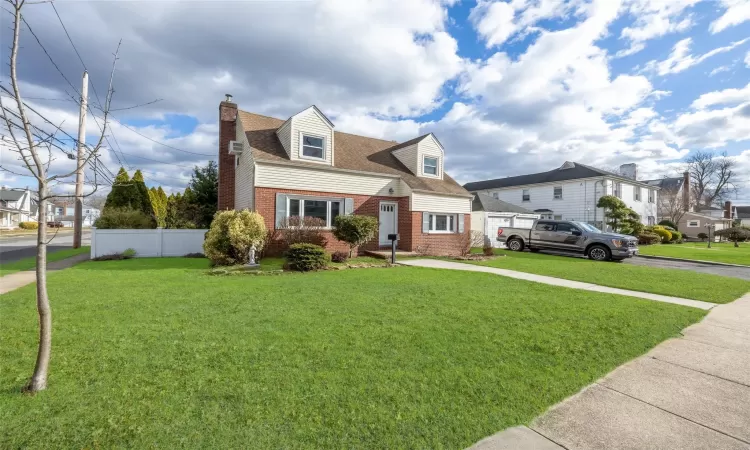 Cape cod-style house with a front yard