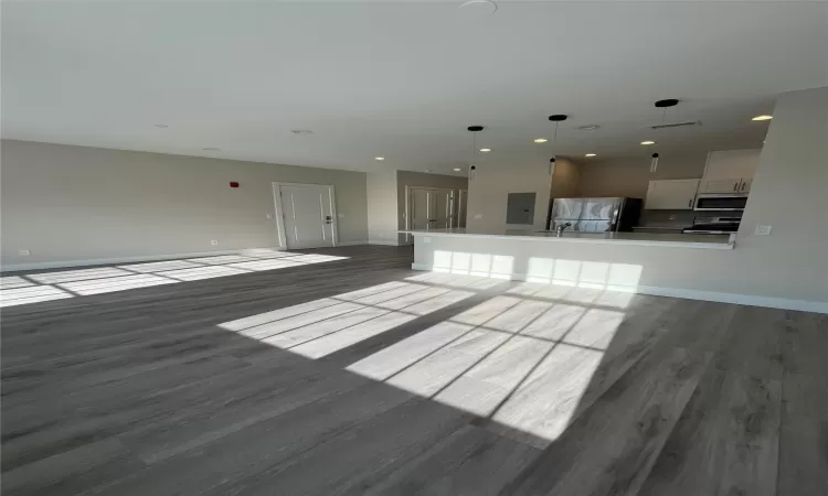 Unfurnished living room featuring sink and dark hardwood / wood-style floors