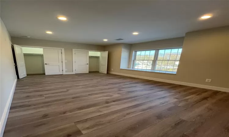 Unfurnished living room with electric panel, hardwood / wood-style flooring, and sink