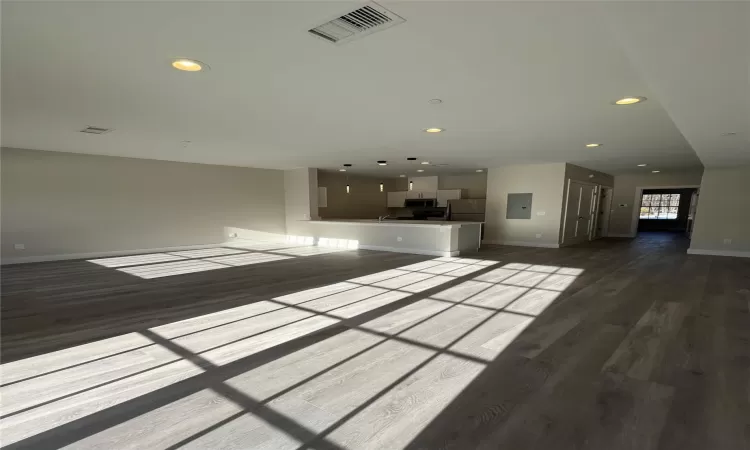 Unfurnished living room featuring electric panel and hardwood / wood-style flooring