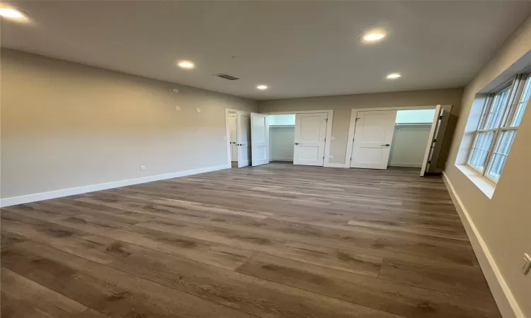 Unfurnished bedroom featuring two closets and dark hardwood / wood-style floors