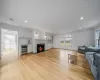 Living room with light hardwood / wood-style floors, crown molding, and wine cooler