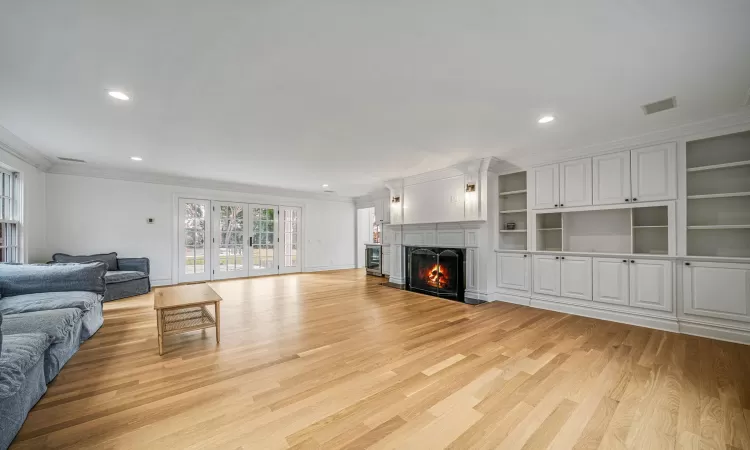 Living room with light hardwood / wood-style floors and ornamental molding