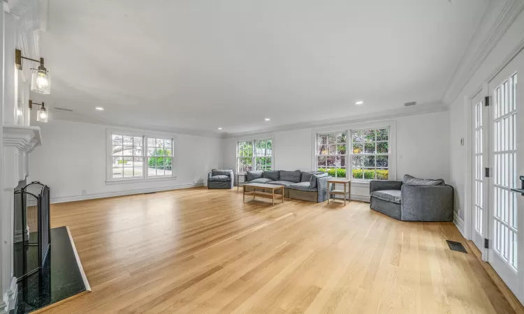 Living room featuring light wood-type flooring and ornamental molding