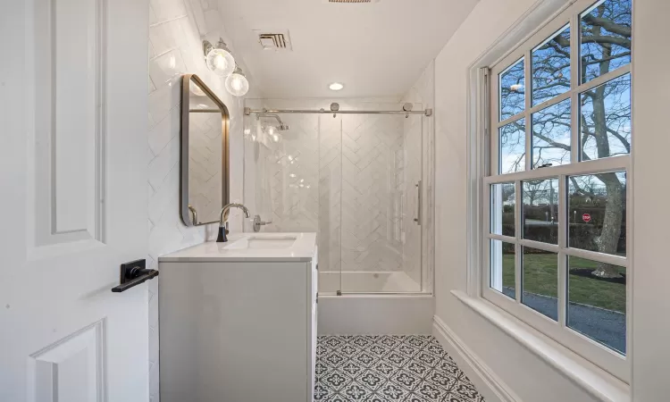 2nd Bedroom with ensuite bath, light hardwood / wood-style flooring, multiple windows, and ornamental molding