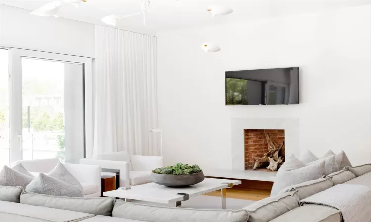 Living room featuring wood-type flooring and a premium fireplace