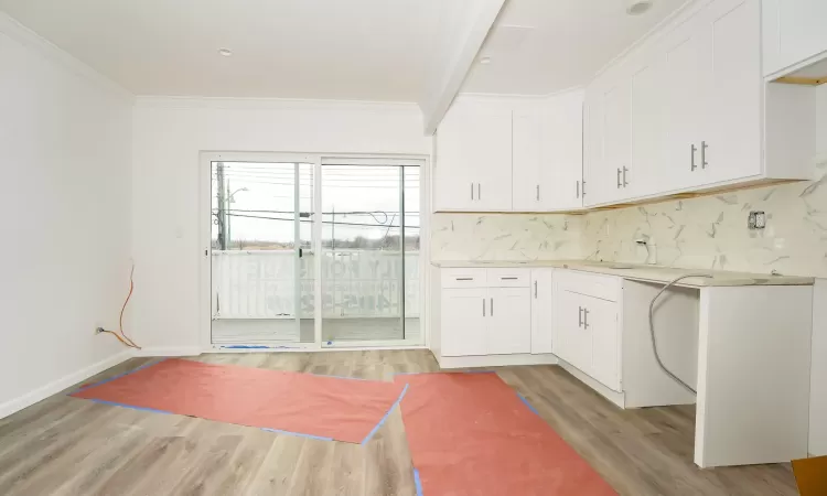 Kitchen featuring sink, white cabinetry, and backsplash