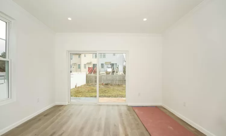 Unfurnished room with light wood-type flooring and crown molding