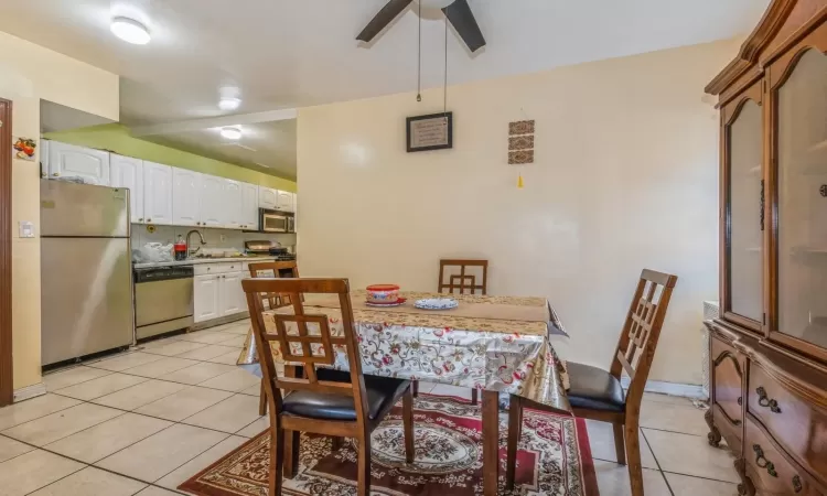 Tiled dining area featuring ceiling fan and sink