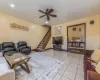 Living room with ceiling fan and light tile patterned flooring