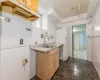 Kitchen with decorative backsplash, light brown cabinetry, sink, tile walls, and white fridge