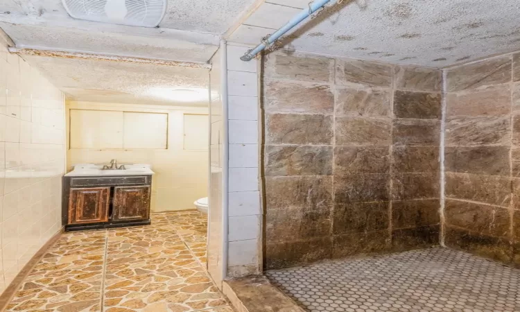 Bathroom with a shower, vanity, and toilet