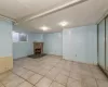 Basement featuring light tile patterned floors and a fireplace