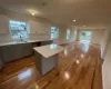 Kitchen with white cabinetry, sink, a center island, light hardwood / wood-style floors, and gray cabinets