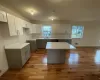 Kitchen with sink, gray cabinets, light hardwood / wood-style floors, a kitchen island, and white cabinetry