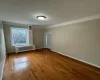 Spare room with hardwood / wood-style floors and radiator heating unit