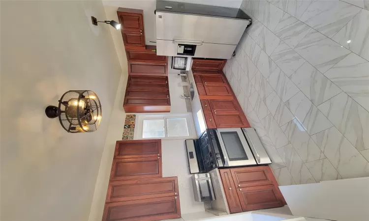 Kitchen featuring refrigerator, range, sink, and an inviting chandelier