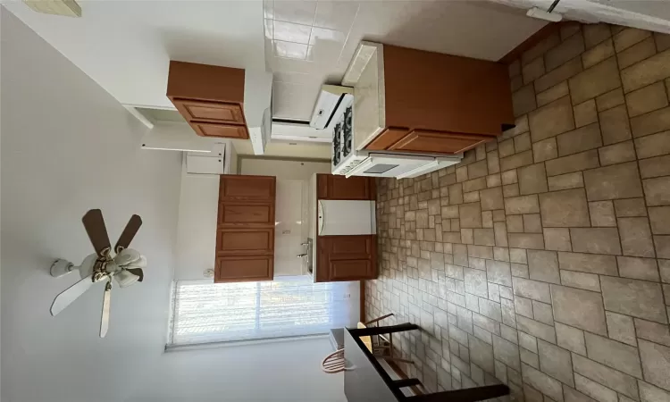 Kitchen with white dishwasher, sink, ceiling fan, range hood, and range