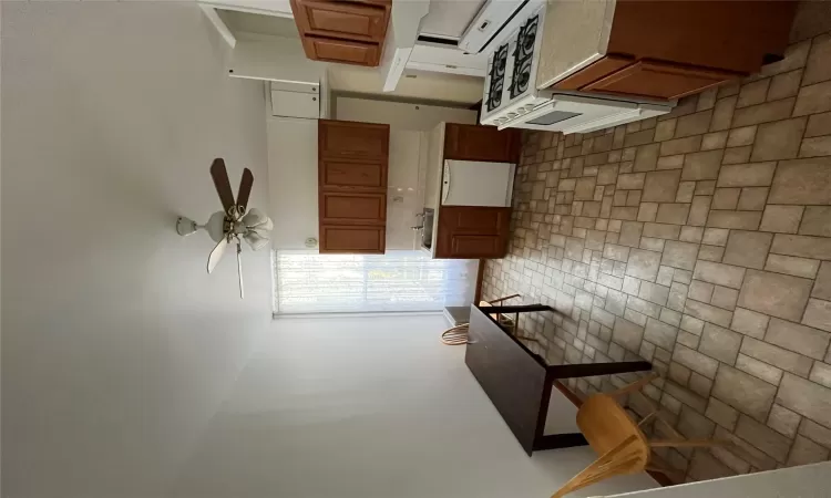 Kitchen featuring dishwashing machine, ceiling fan, range, and sink