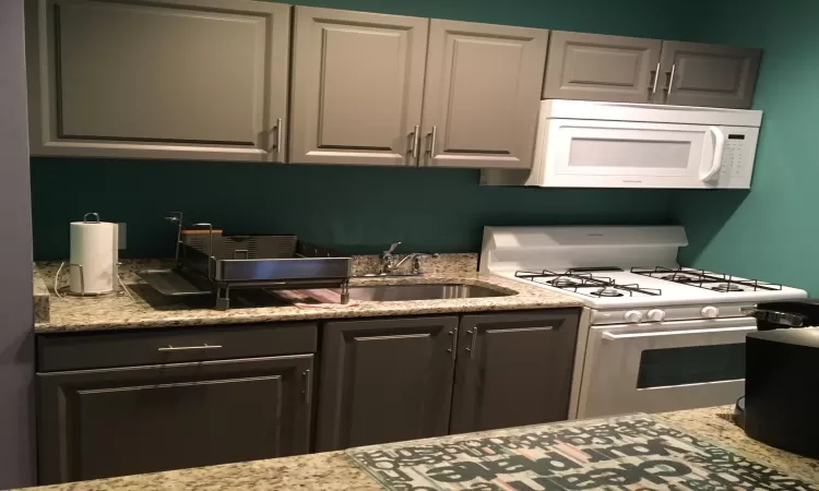 Kitchen featuring white appliances and sink