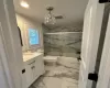 Full bathroom with combined bath / shower with glass door, vanity, an inviting chandelier, and toilet